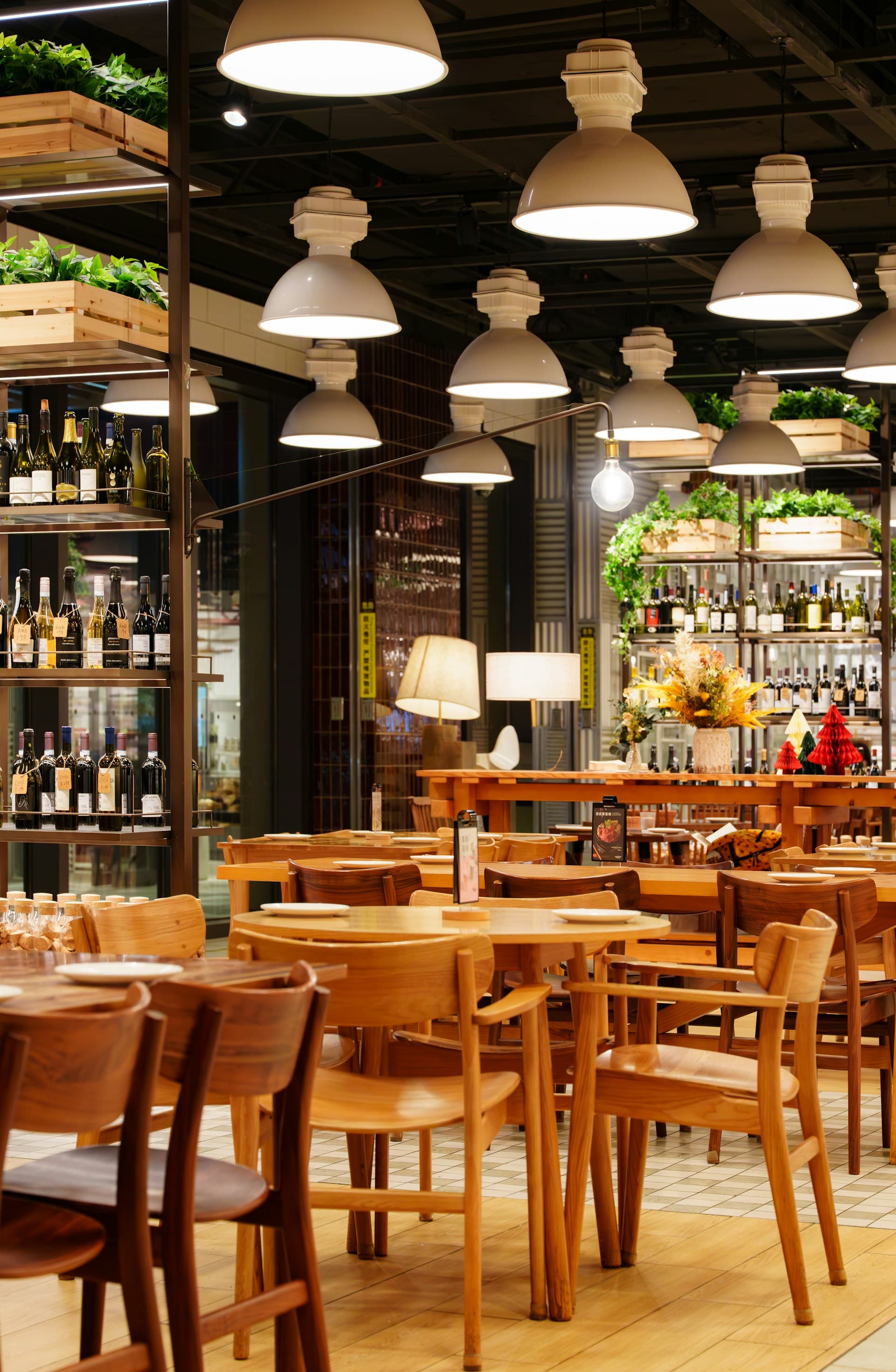 A warmly lit restaurant bar with shelves of bottles and pendant lights.